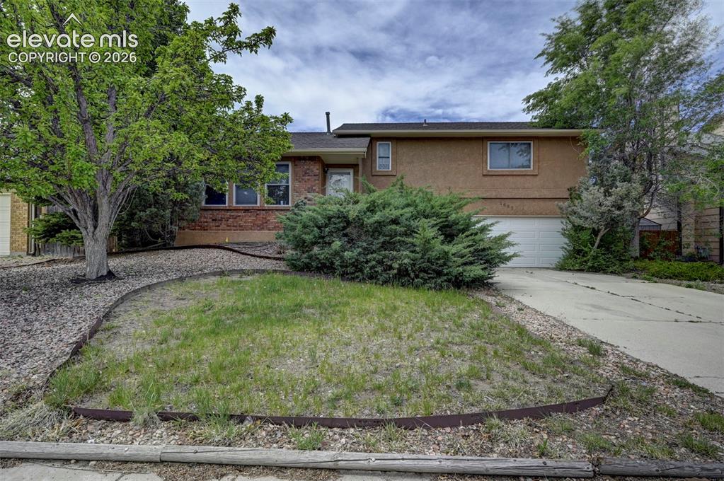 Image 8 of 43: Split-level residence featuring a brick and stucco exterior