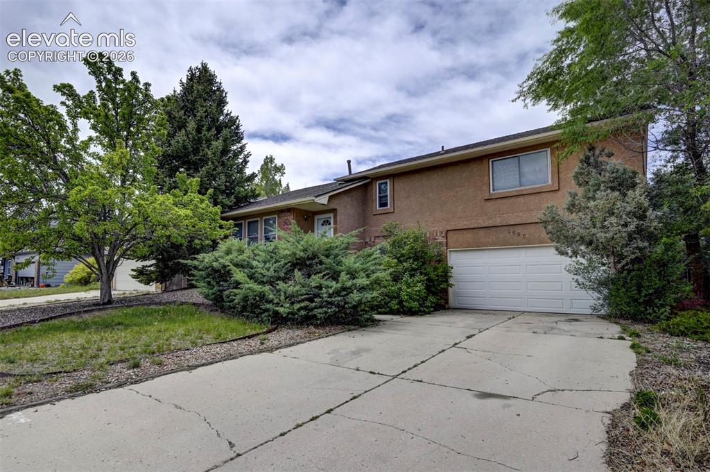 Image 9 of 43: Two-story stucco exterior featuring a two-car garage with a white overhead