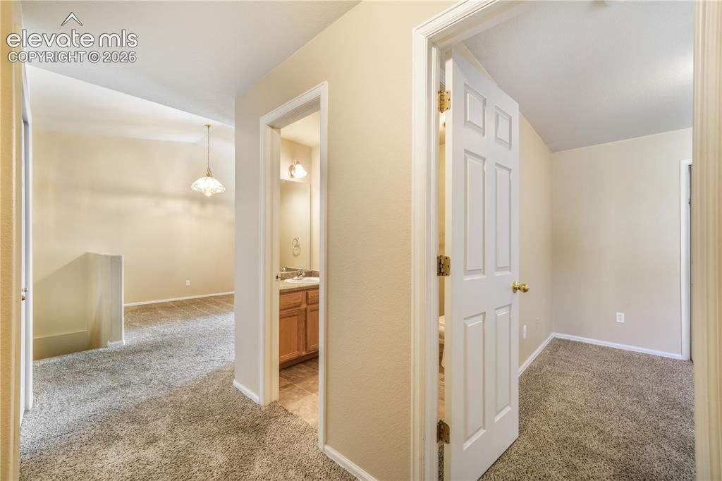 Image 11 of 50: Hallway view of first bedroom, main floor at front of home with connecting
