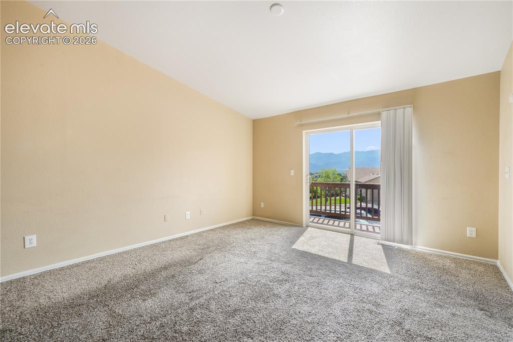 Image 23 of 50: Living room with balcony access and mountain views