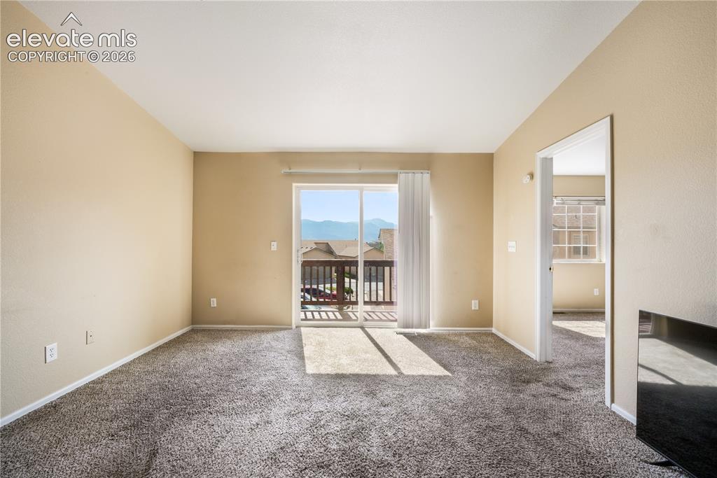 Image 26 of 50: Living room with balcony access and mountain views