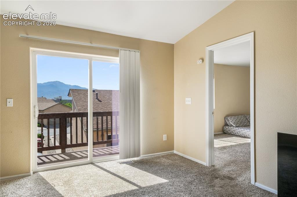 Image 28 of 50: Living room with balcony access and mountain views