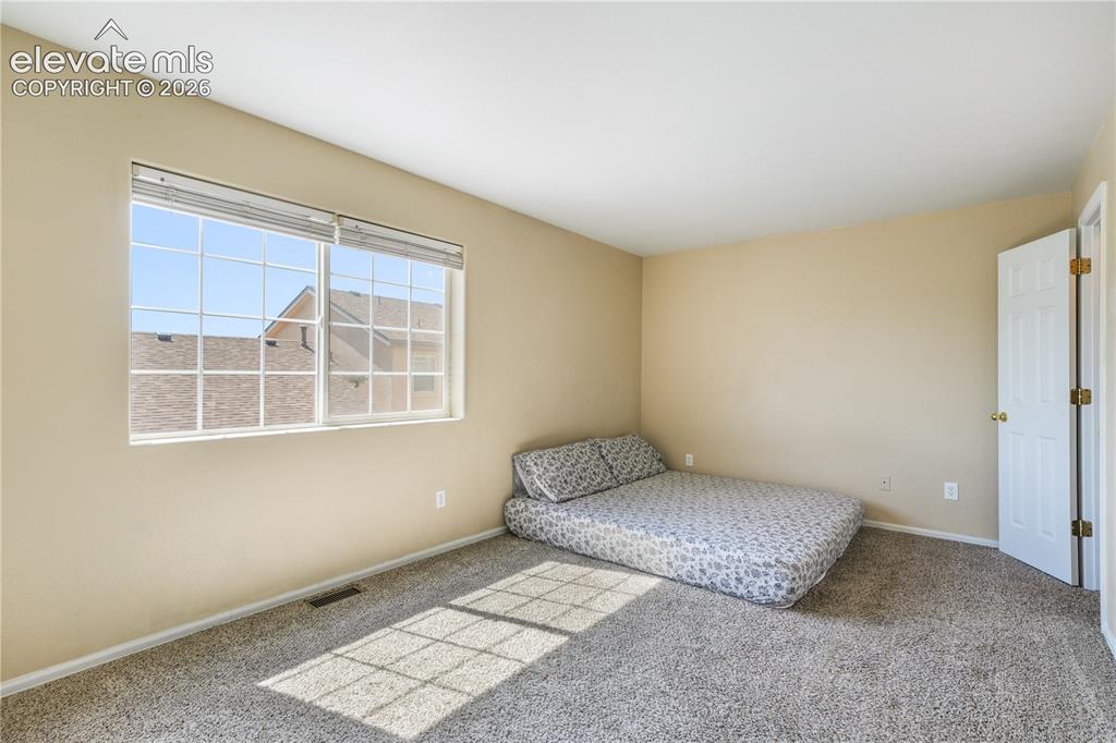 Image 29 of 50: Main level primary bedroom with walk in closets and ensuite bathroom with 2