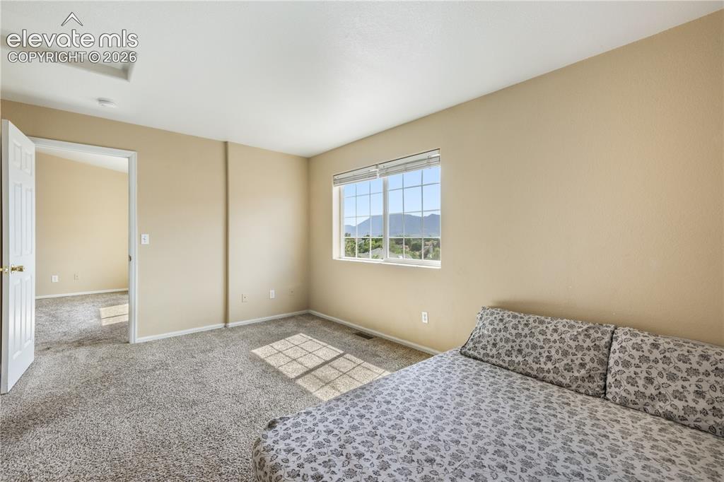 Image 31 of 50: Main level primary bedroom with walk in closets and ensuite bathroom with 2