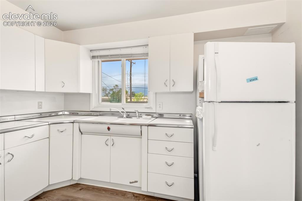 Image 10 of 25: Vintage kitchen with original steal cabinets and LVP flooring