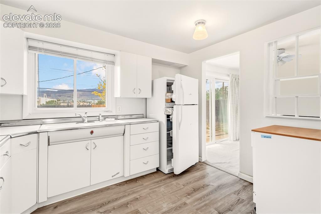Image 11 of 25: Vintage kitchen with original steal cabinets and LVP flooring