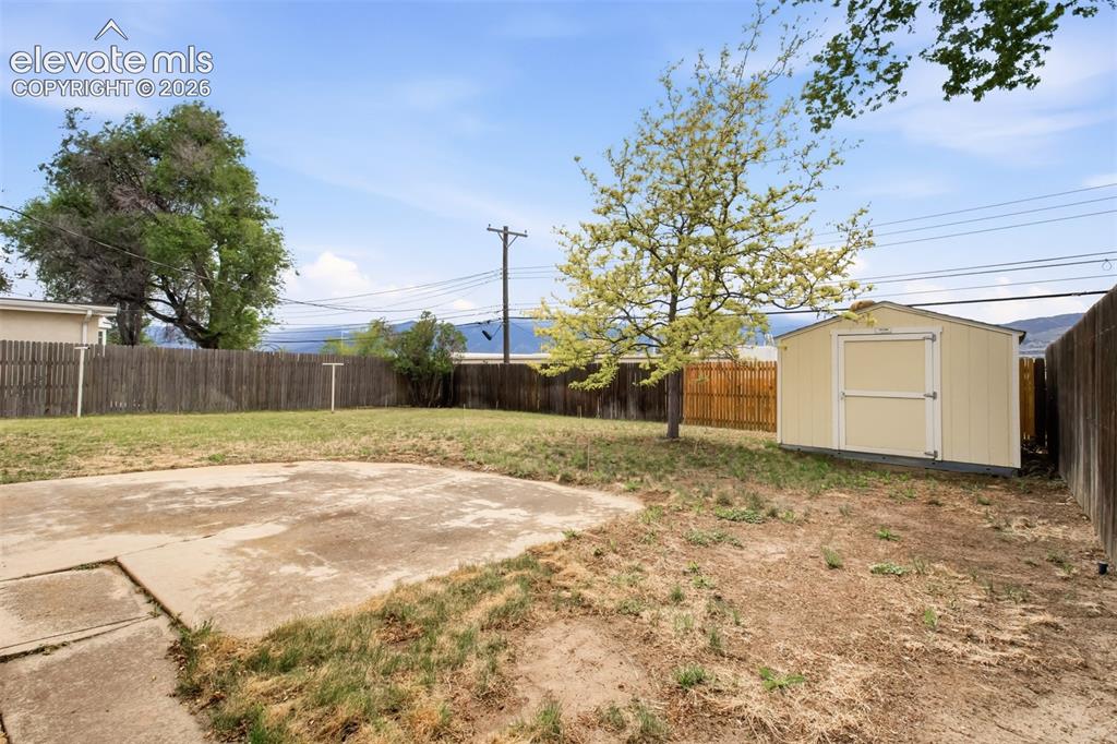 Image 7 of 25: Back patio and yard from the walk out. Look any the mountains behind, espec