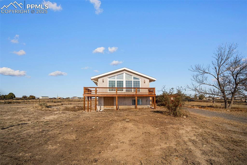 Caption: Back of house featuring a deck and a view of countryside