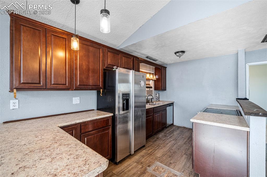 Image 6 of 12: Kitchen with dark wood-style floors, a textured ceiling, light countertops,