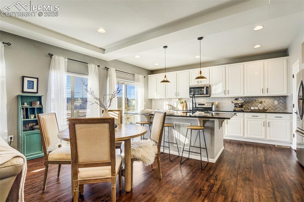 Image 6 of 43: Dining area with additional seating at the kitchen island. 