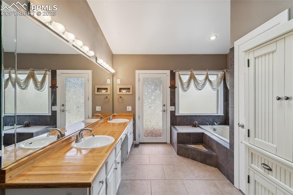 Image 25 of 50: Large 5-piece master bath with custom wood counter, heated tile floor, spa 