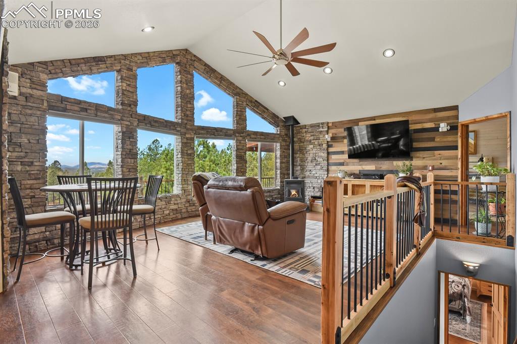 Image 12 of 41: Living area featuring a Pellet stove, ceiling fan, wood finished floors, a
