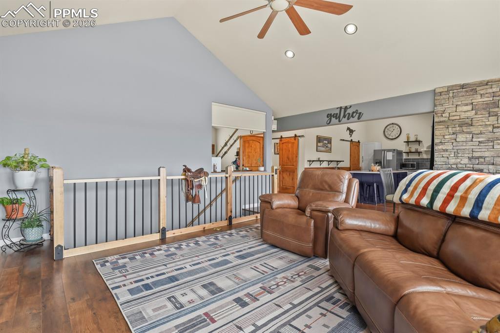 Image 15 of 41: Living area featuring ceiling fan, lofted ceiling, wood-type flooring, and