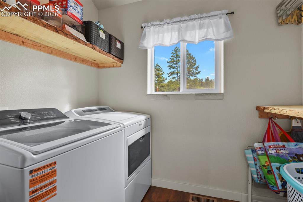 Image 20 of 41: Laundry area with Cabinets and independent washer and dryer and dark wood f