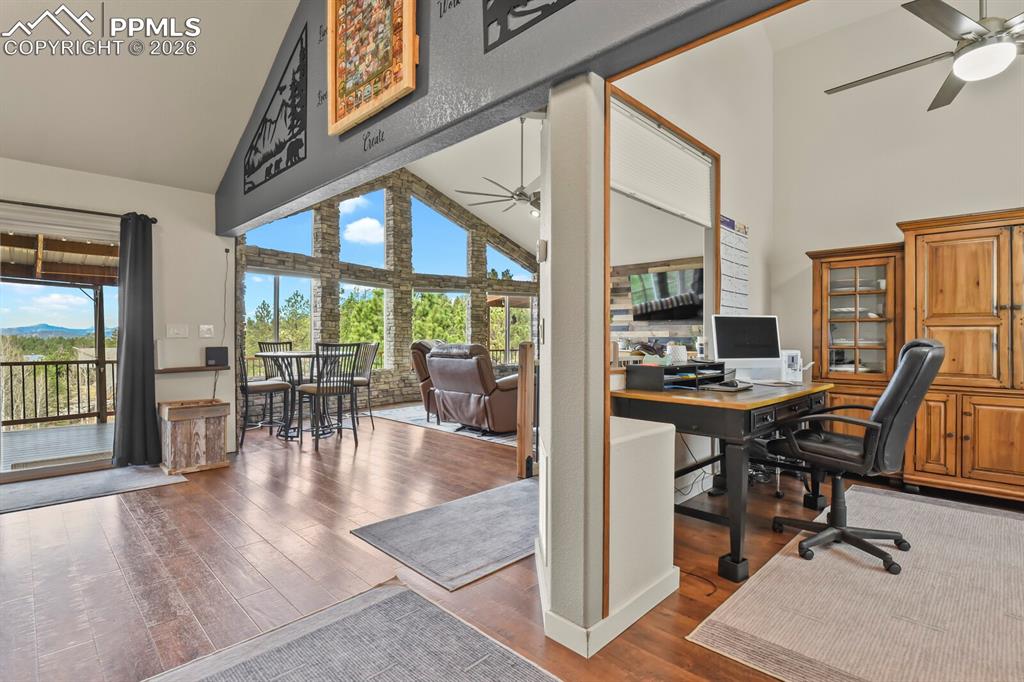 Image 3 of 41: Home office featuring ceiling fan, vaulted ceiling, and dark wood-style flo