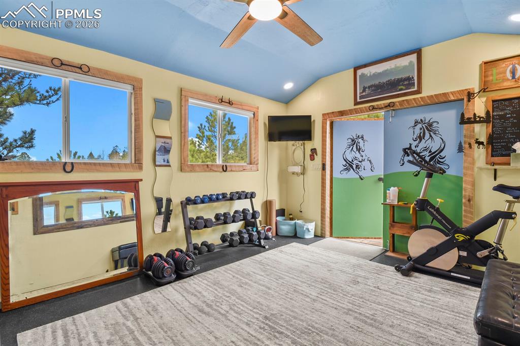 Image 34 of 41: Workout area featuring ceiling fan, lofted ceiling, natural light, and rece