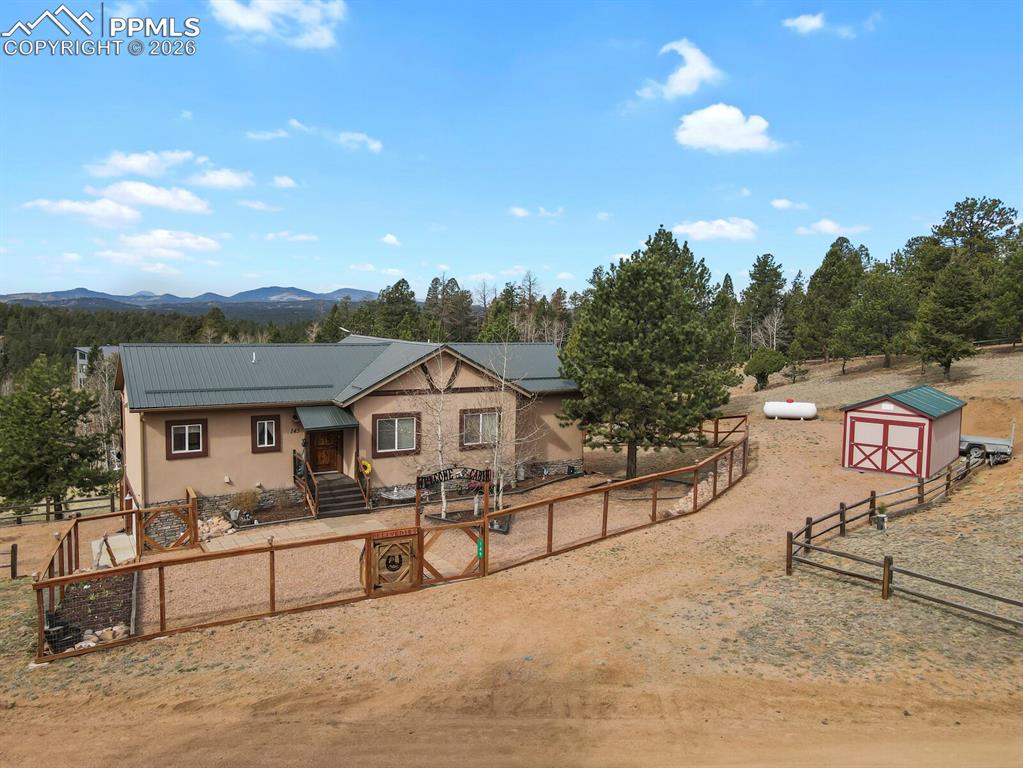 Image 36 of 41: View of front of house with a gate, a fenced front yard, an outbuilding, st
