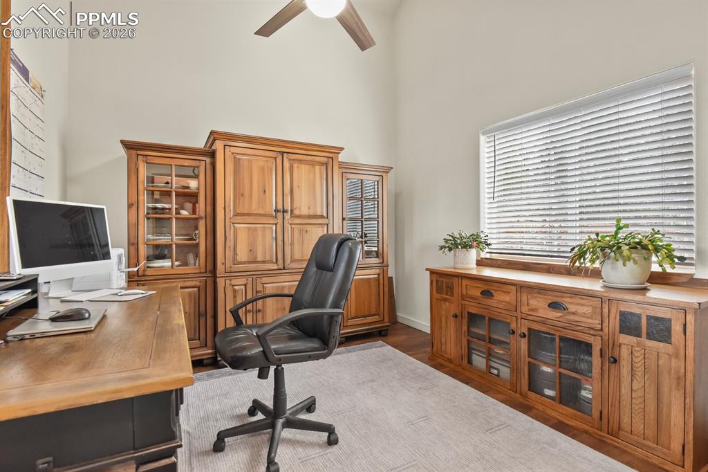 Image 4 of 41: Office area with ceiling fan, dark wood-type flooring, and a high ceiling