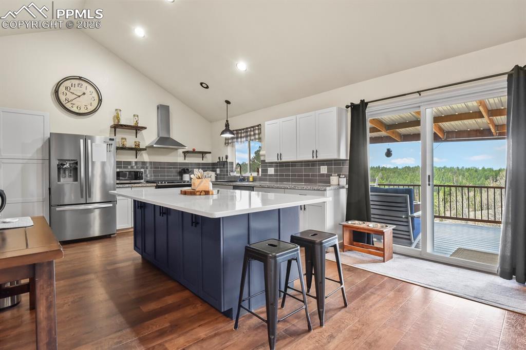 Image 8 of 41: Two tone kitchen with two tone cabinetry, lofted ceiling, stainless steel f