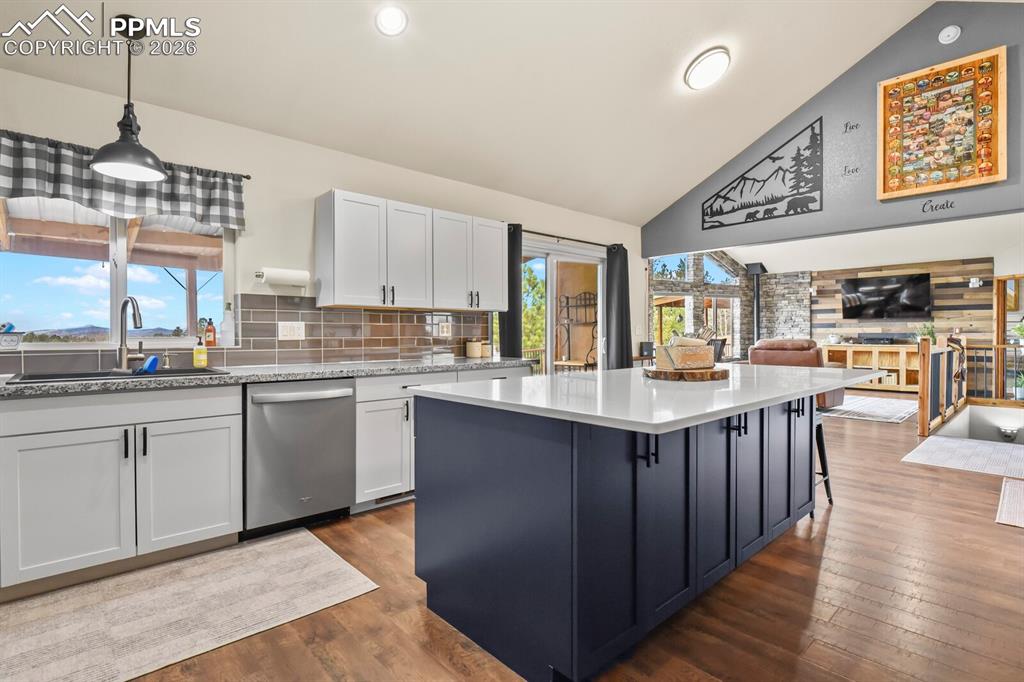 Image 9 of 41: Two tone kitchen featuring two tone color scheme, open floor plan, dark woo