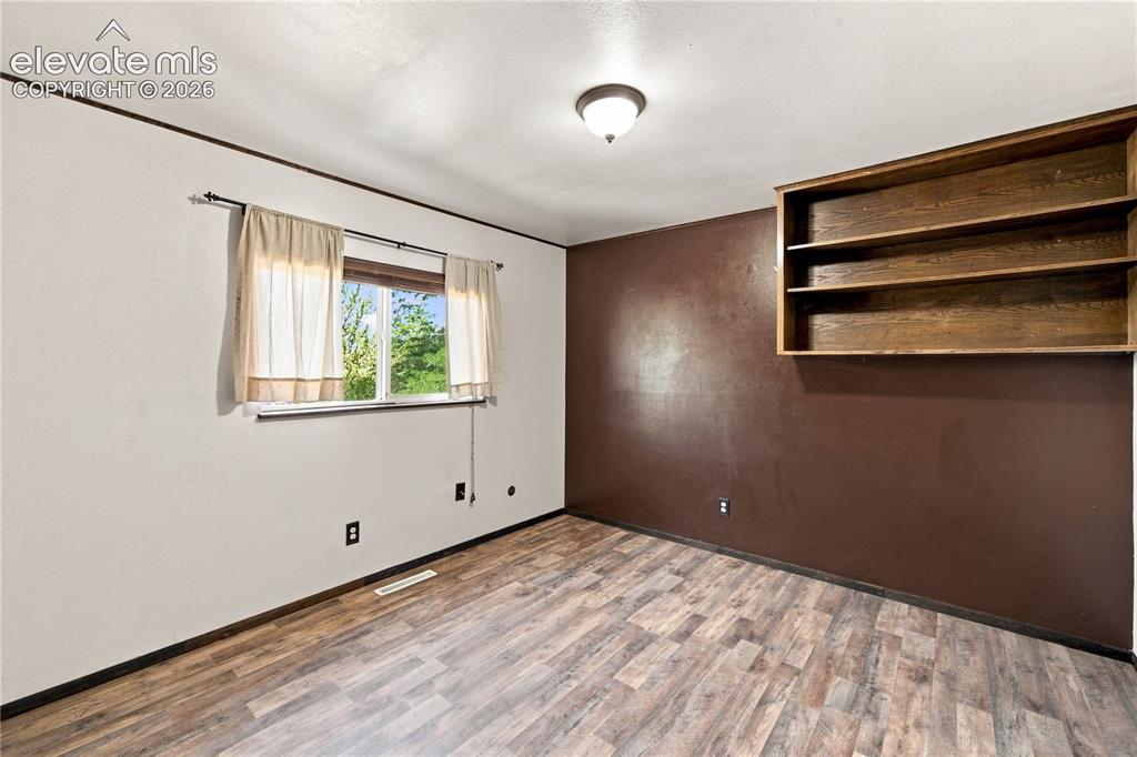 Image 15 of 39: Built-in shelving, wood-finish flooring, and a semi-flush mount ceiling lig