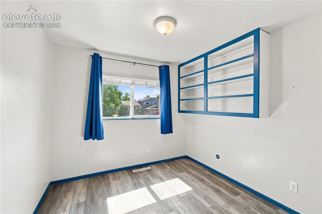 Image 18 of 39: Wood-finish flooring with white walls and contrasting trim