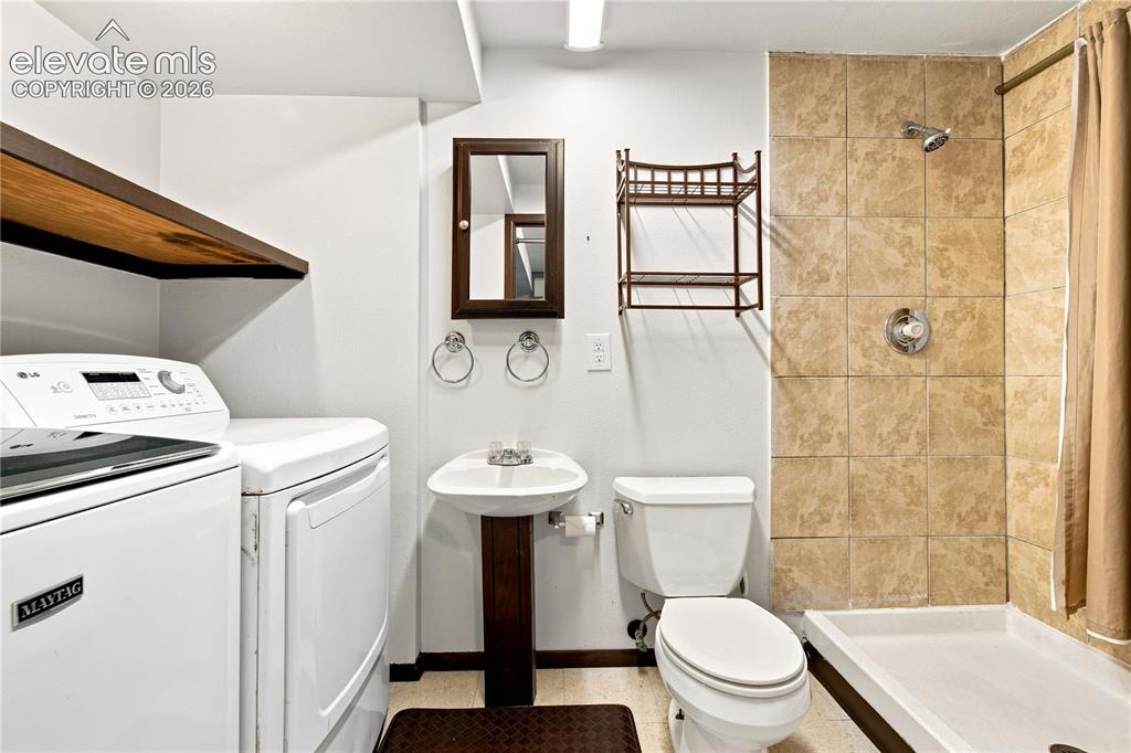 Image 24 of 39: Full bathroom featuring a ceramic tile shower, white pedestal sink, and a f
