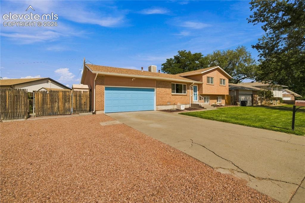 Image 34 of 39: Brick and stucco exterior with a light blue garage door, concrete driveway,