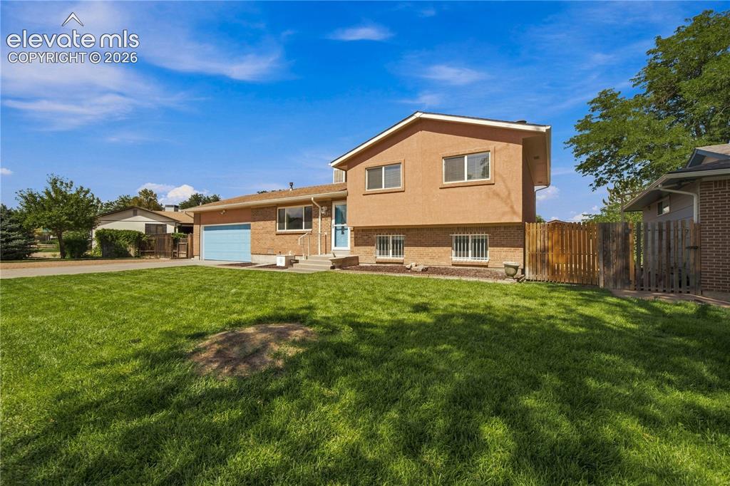 Image 35 of 39: Two-story stucco and brick exterior featuring a front-facing garage, a conc