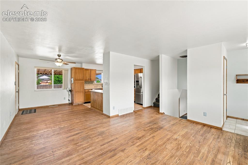 Image 5 of 39: Open-concept living area with wood-finish flooring, white walls, and a ceil