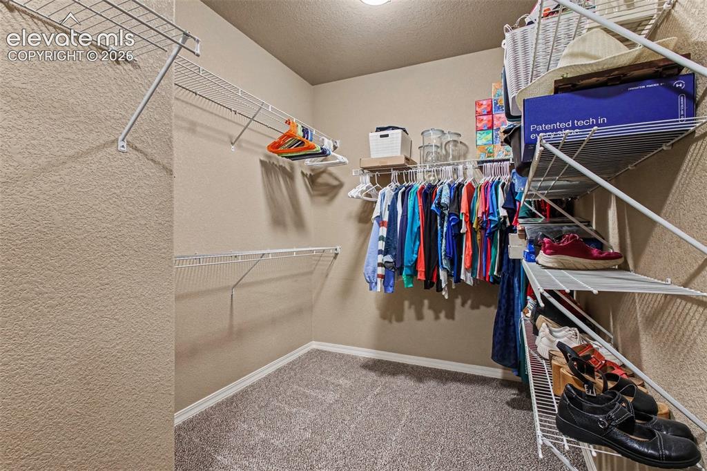 Image 20 of 47: Primary Bedroom Walk-in Closet. More closet space to the left not visible i