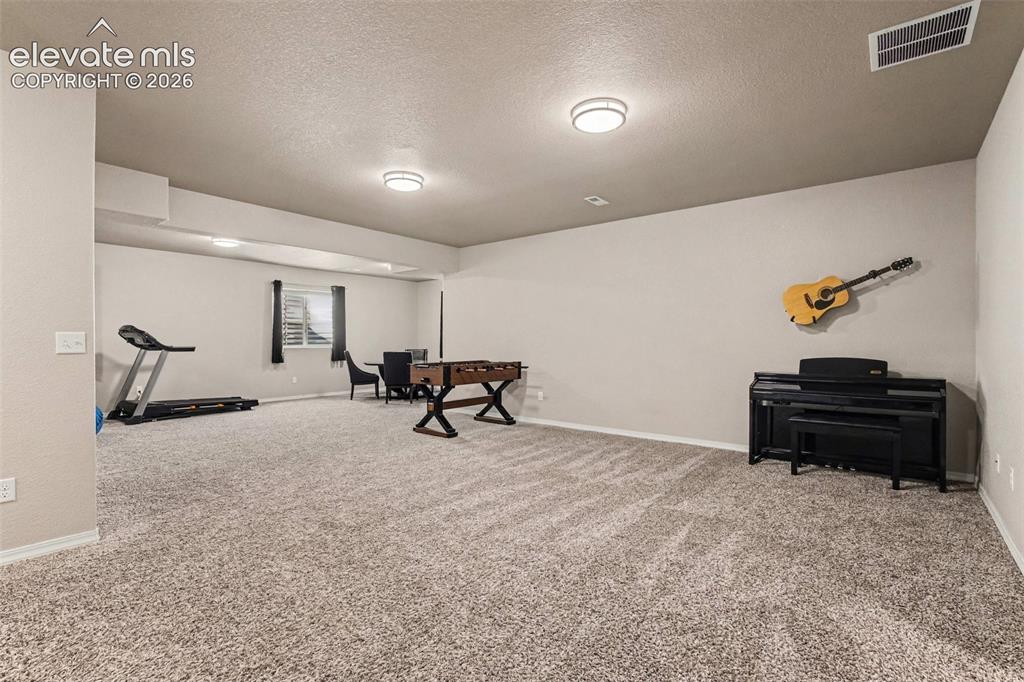 Image 26 of 47: Basement Family Room w/ Wet Bar