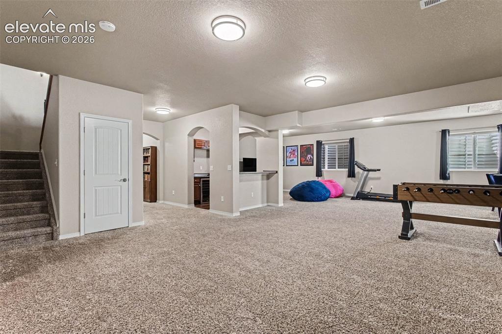 Image 27 of 47: Basement Family Room w/ Wet Bar
