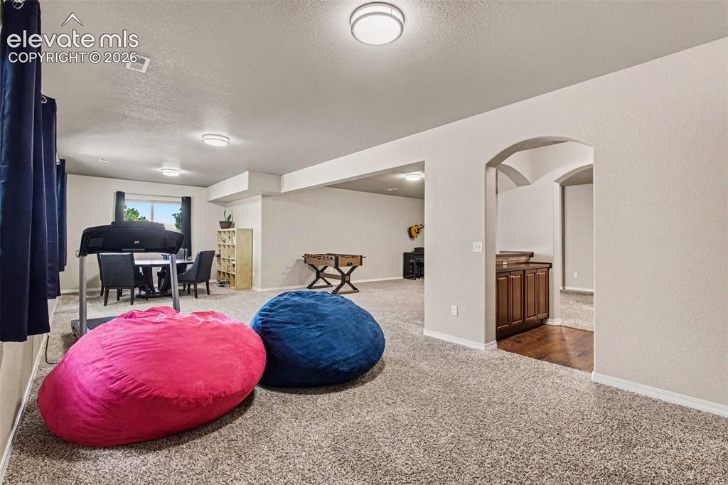 Image 29 of 47: Basement Family Room w/ Wet Bar