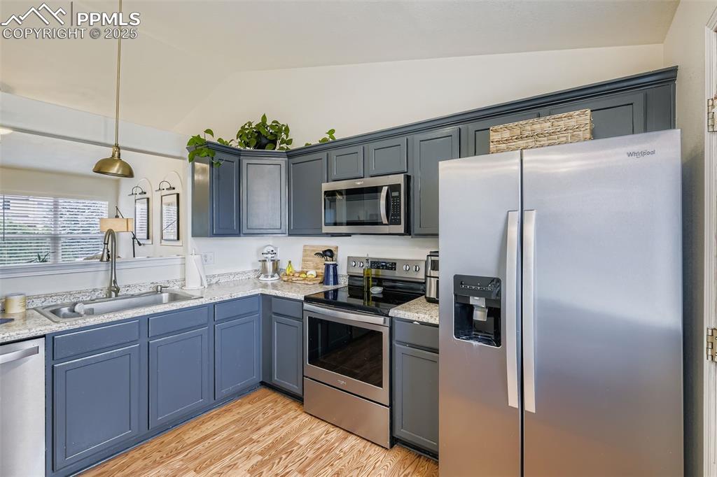 Image 11 of 28: Kitchen featuring appliances with stainless steel finishes, light wood-type