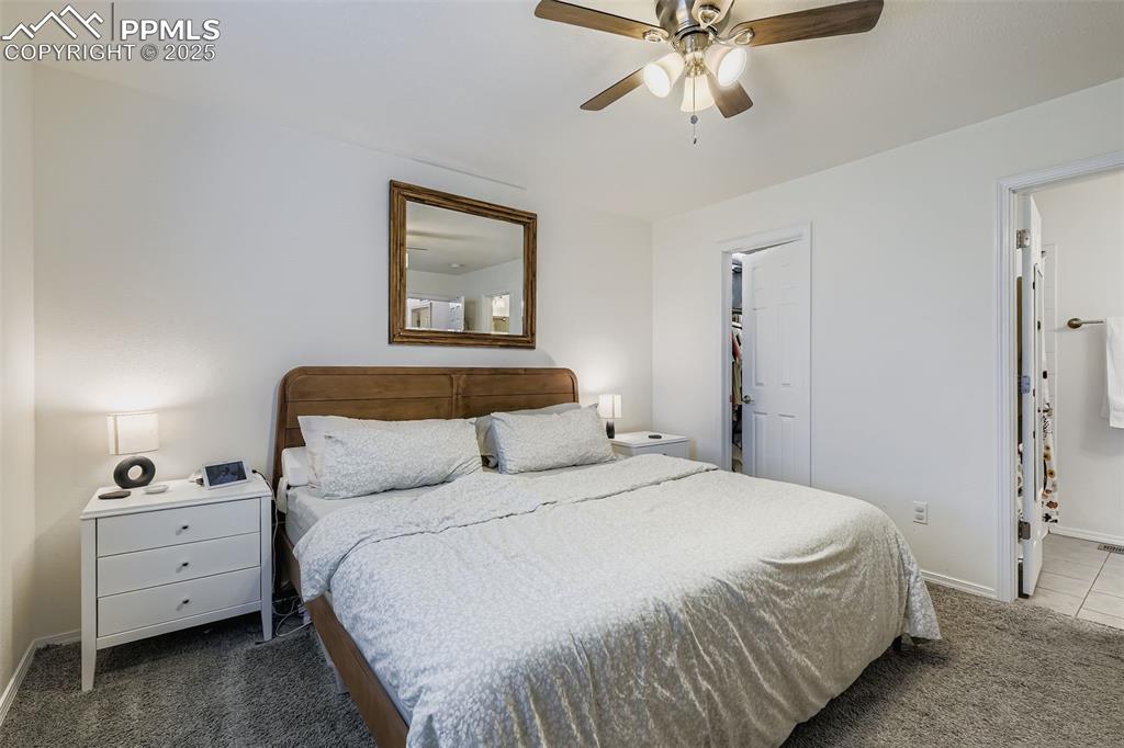 Image 16 of 28: Carpeted bedroom with ceiling fan and a spacious closet