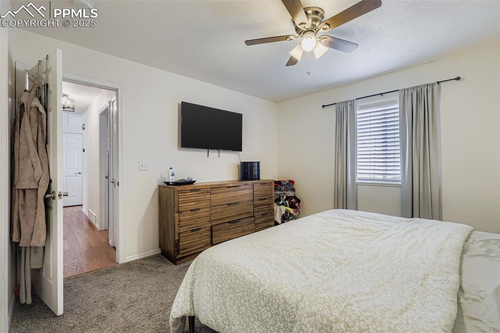 Image 18 of 28: Carpeted bedroom with ceiling fan and baseboards