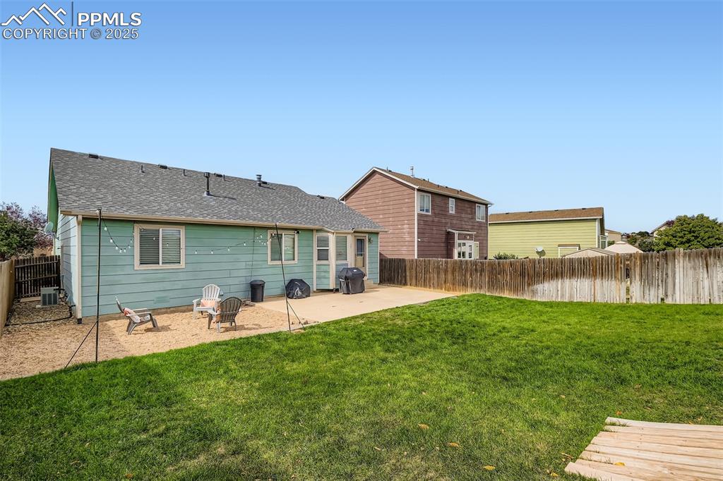 Image 28 of 28: Rear view of house featuring roof with shingles, a patio area, and a fenced