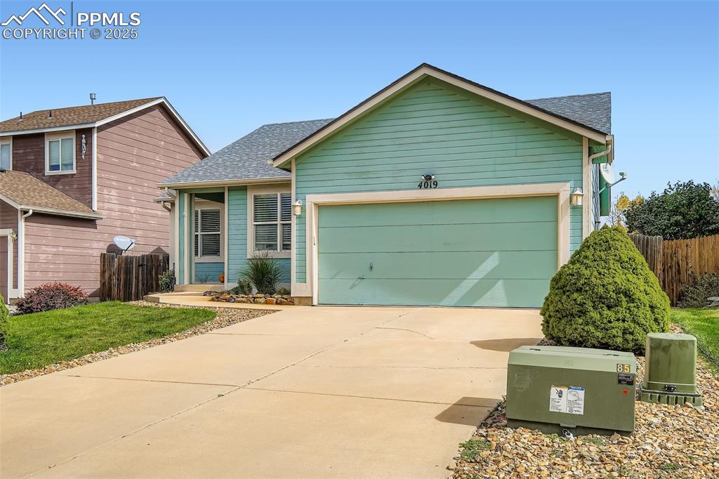Image 3 of 28: View of front of house with concrete driveway, roof with shingles, and a ga