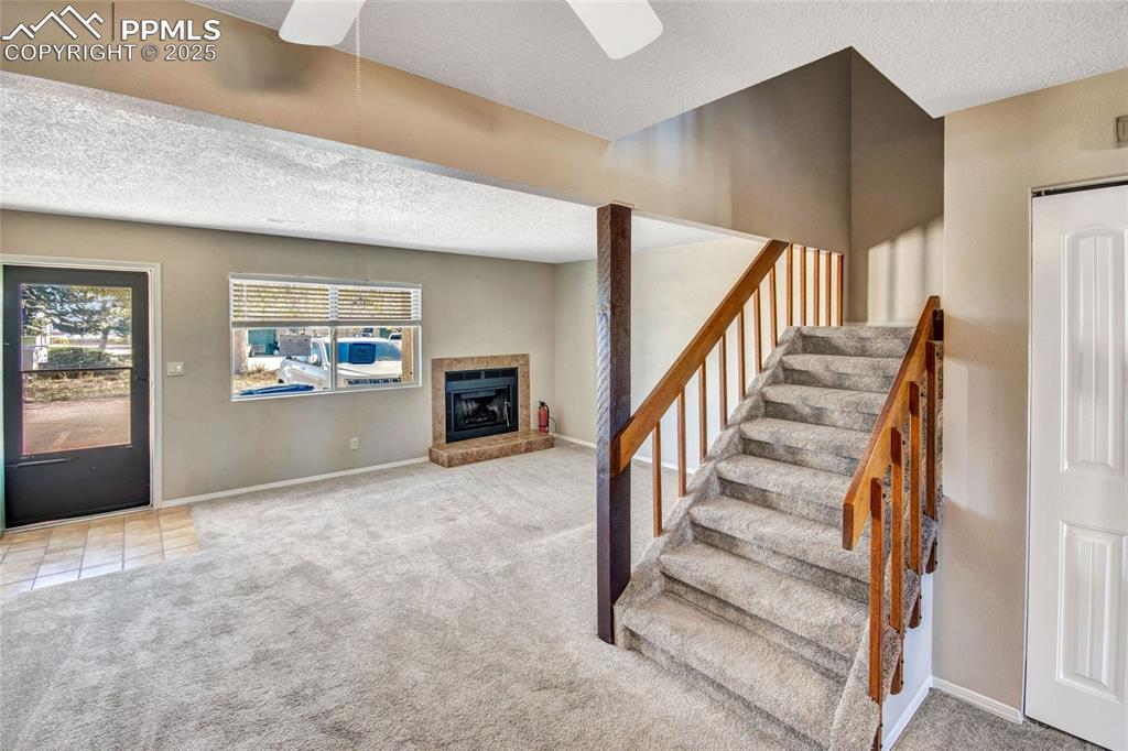 Image 14 of 35: Staircase featuring a textured ceiling, carpet, a brick fireplace, ceiling 