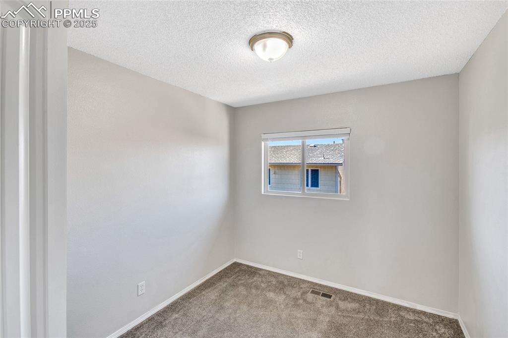 Image 22 of 35: Spare room with carpet flooring and a textured ceiling
