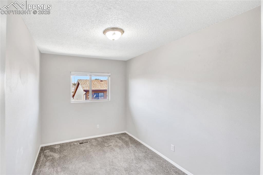 Image 25 of 35: Carpeted spare room featuring a textured ceiling and baseboards