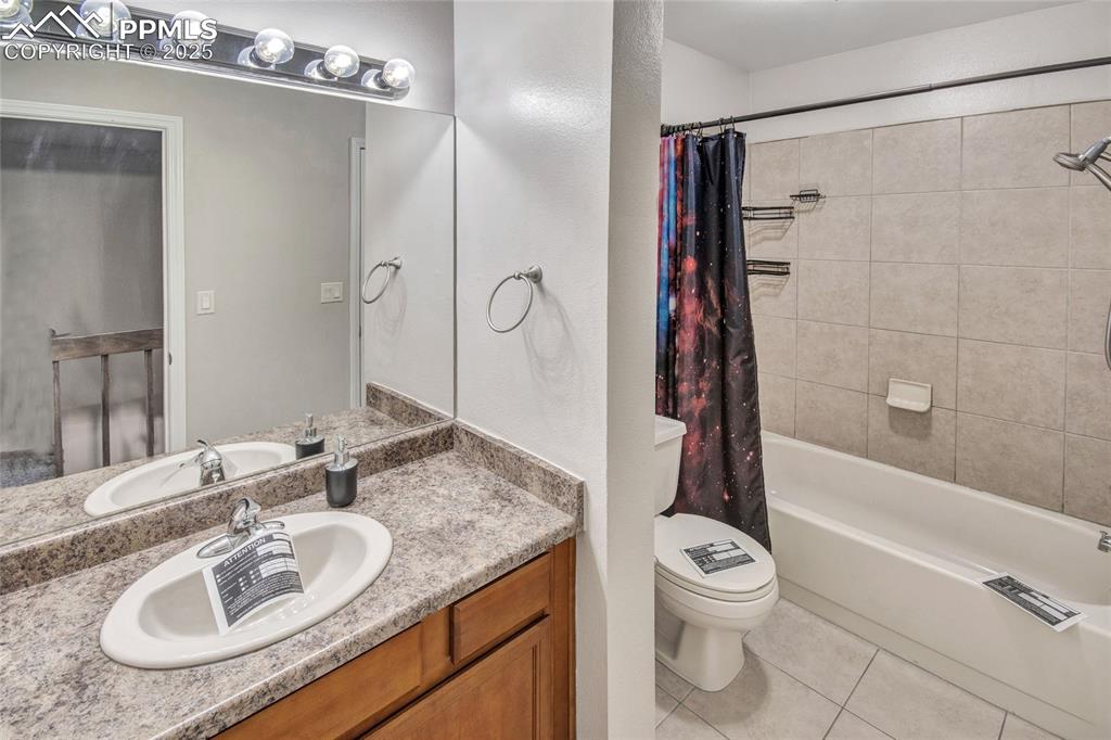 Image 27 of 35: Full bathroom with shower / bath combo with shower curtain, tile patterned 