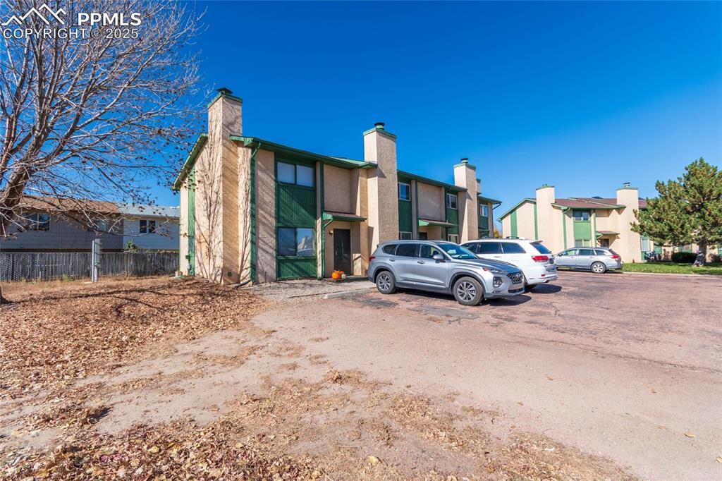 Image 3 of 35: View of building exterior with uncovered parking and a residential view