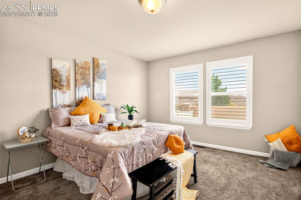 Image 20 of 37: Main level maaster bedroom with large windows and adjoining bathroom