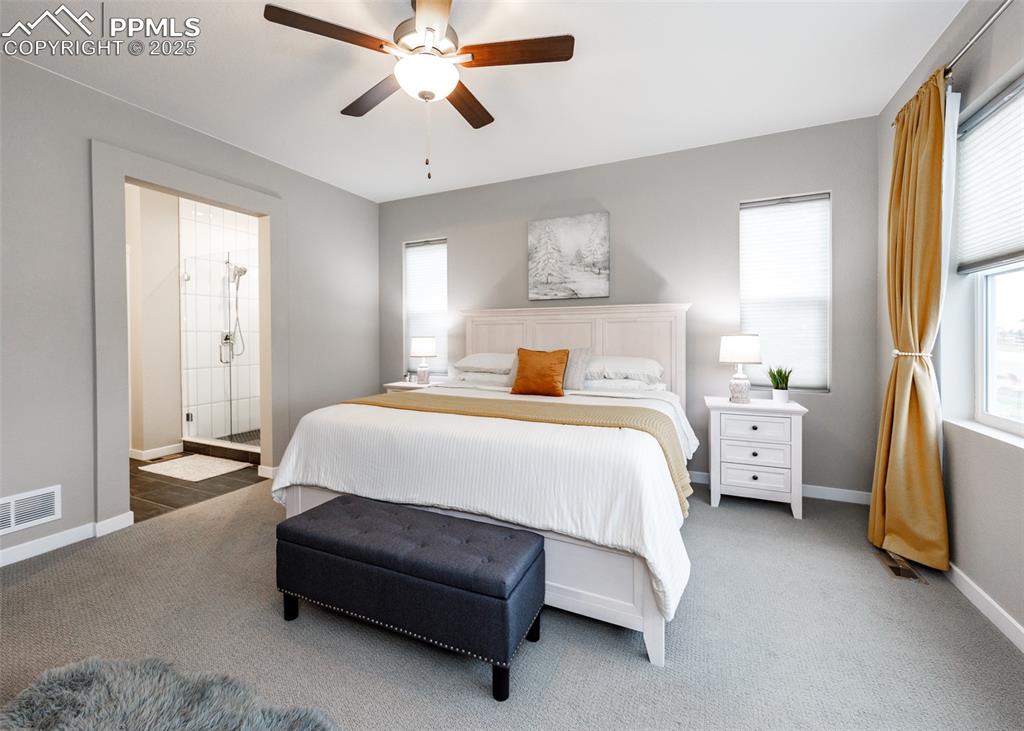 Image 19 of 37: Spacious bedroom with abundant natural light, light carpeting, ceiling fan,