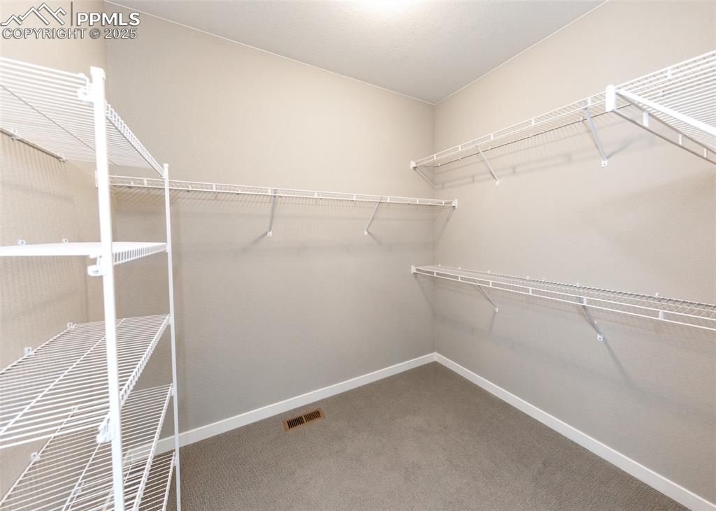 Image 22 of 37: Generous walk-in closet offers plenty of room for organization and wardrobe