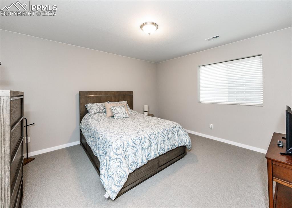 Image 27 of 37: Spacious basement bedroom provides a comfortable retreat with plenty of roo