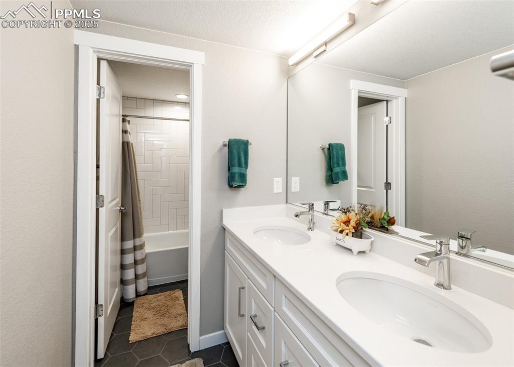 Image 28 of 37: right basement full bathroom with a double vanity, providing ample space fo