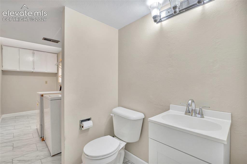 Image 10 of 26: Half bath attached to laundry